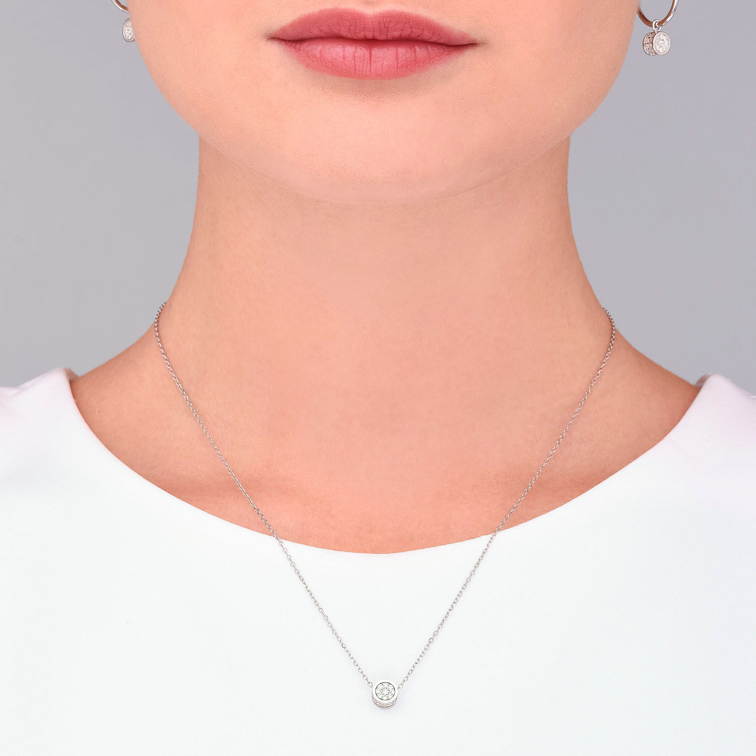 Colar delicado com pingente circular de diamantes.