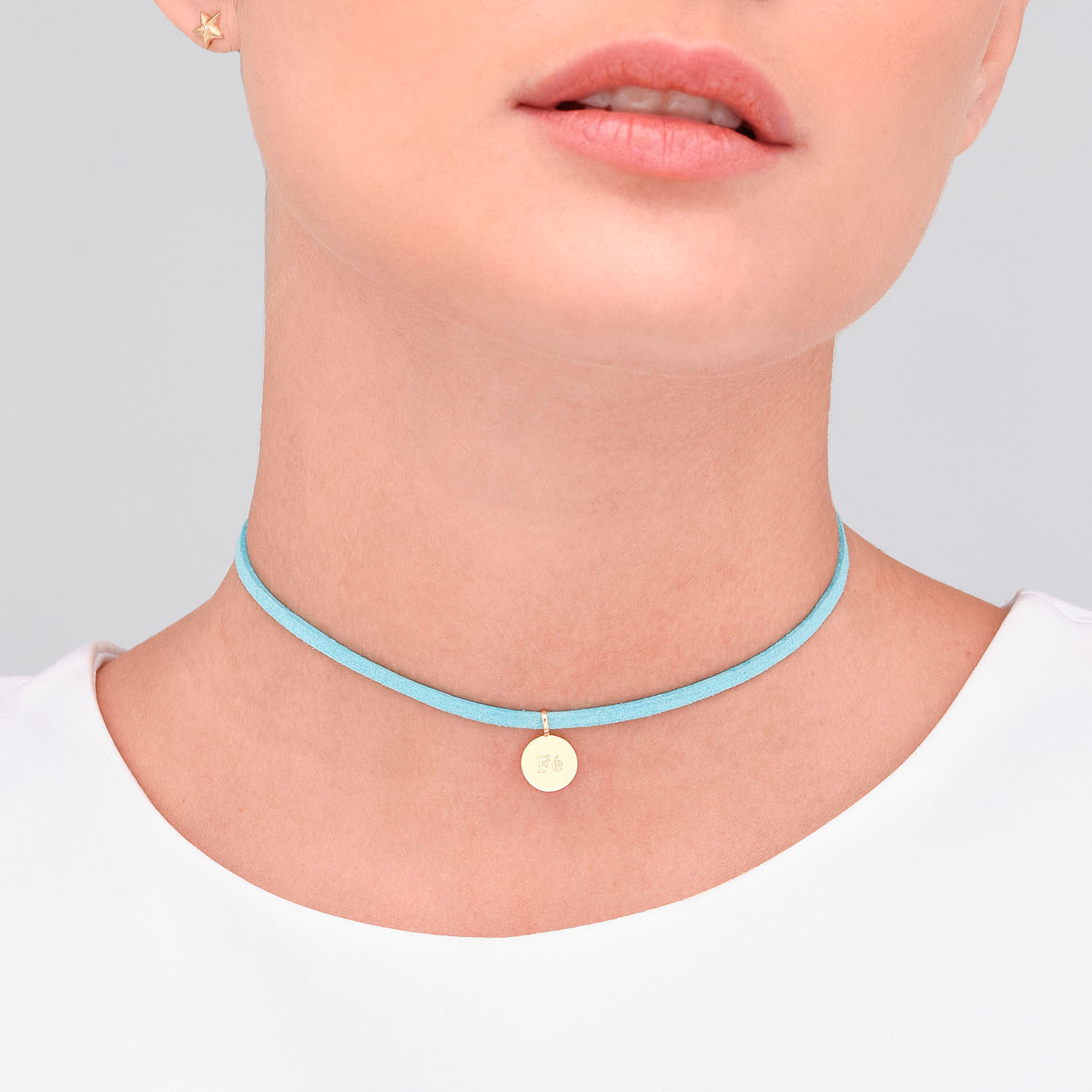 Colar delicado azul com pingente dourado redondo e gravação na frente.