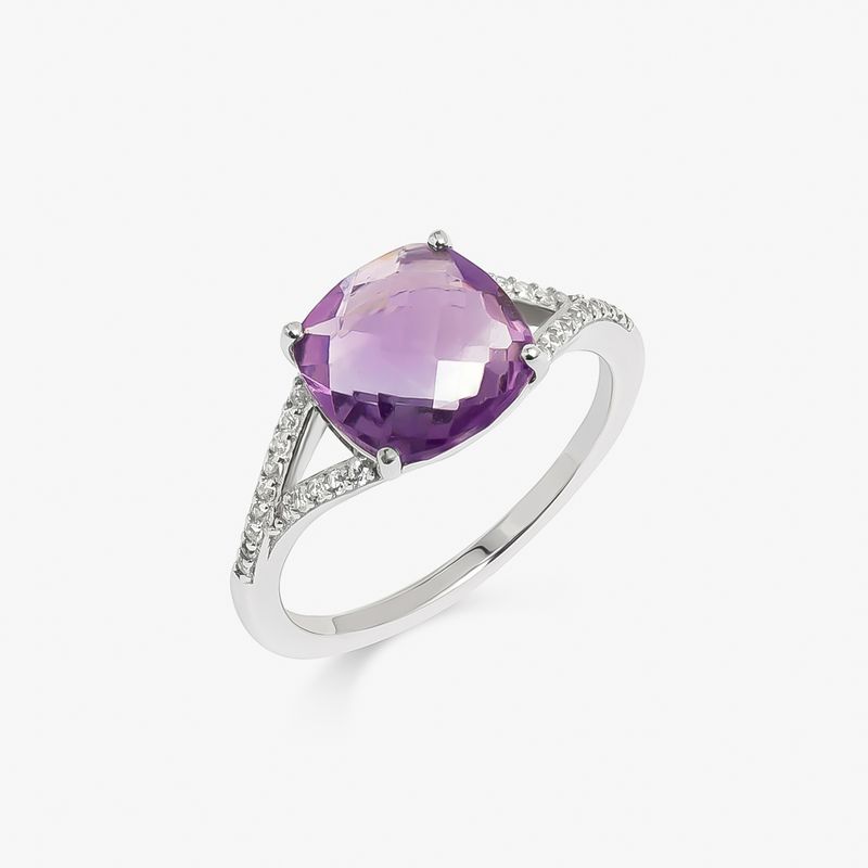 Anel com pedra roxa grande e lapidada, em aro prateado, com detalhes de pequenos cristais ao redor da pedra.