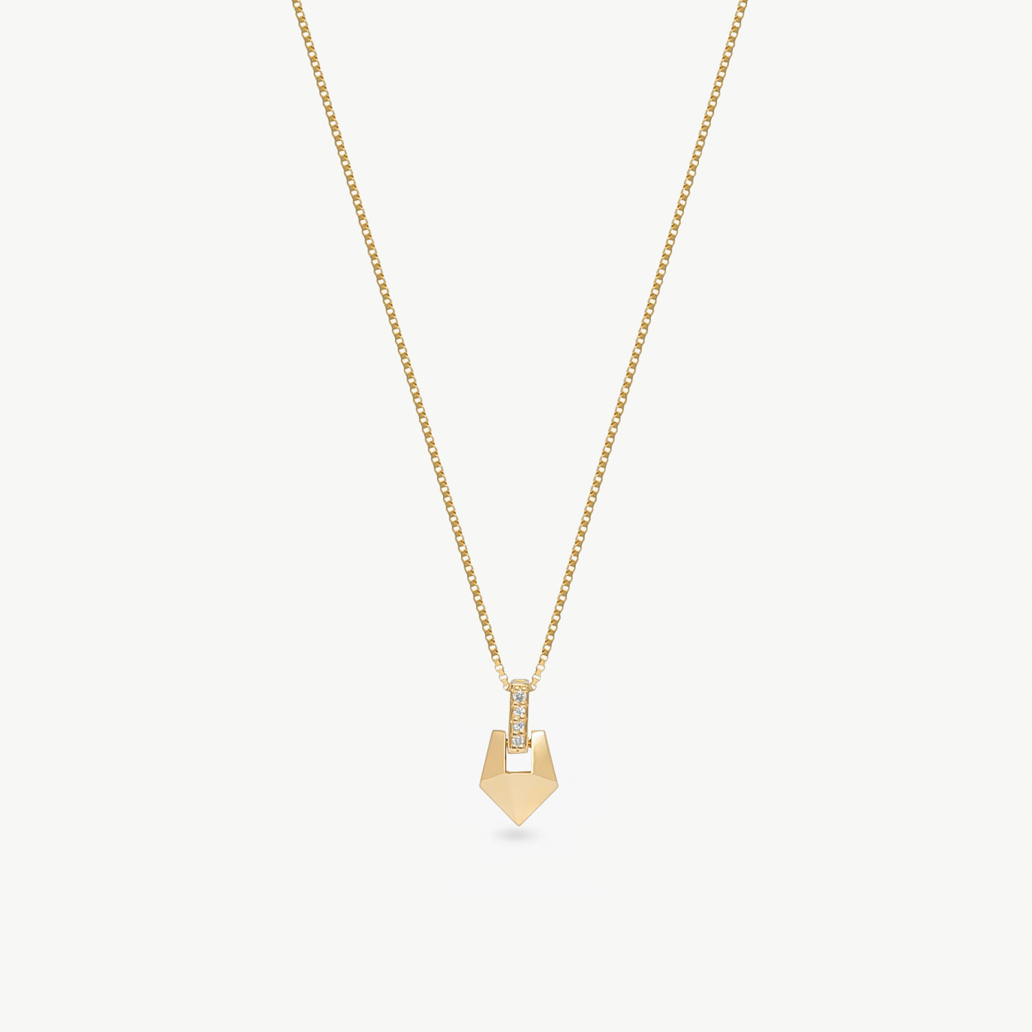 Colar dourado com pingente de formato geométrico e detalhes de pedra brilhante.