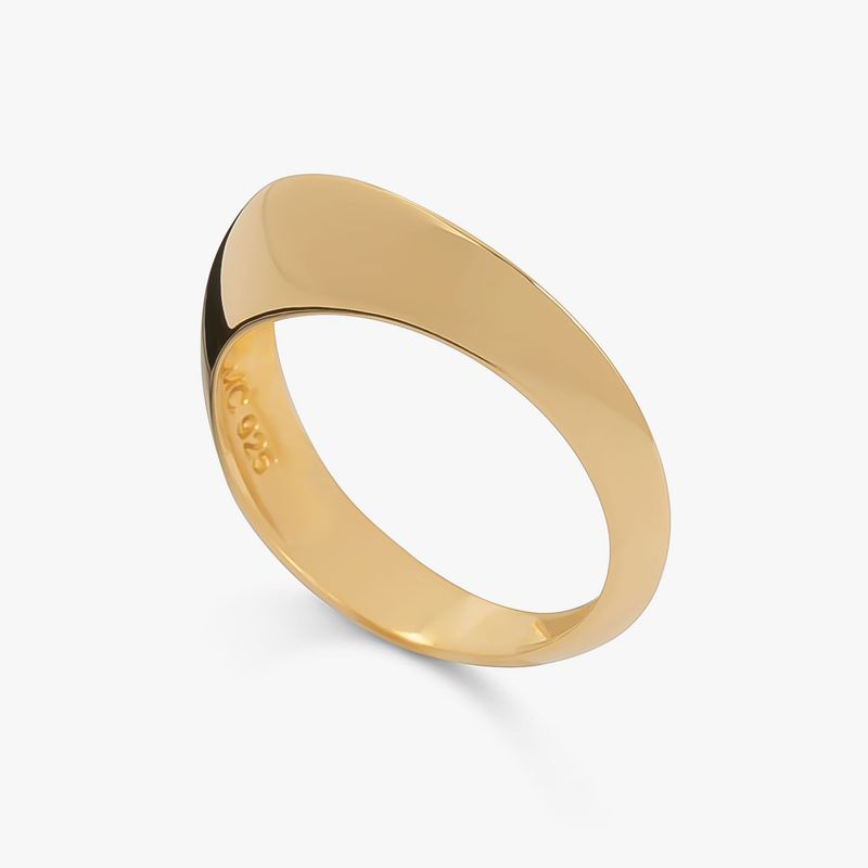 Anel dourado com detalhe preto, com design simples e elegante, visto de lado em fundo branco.