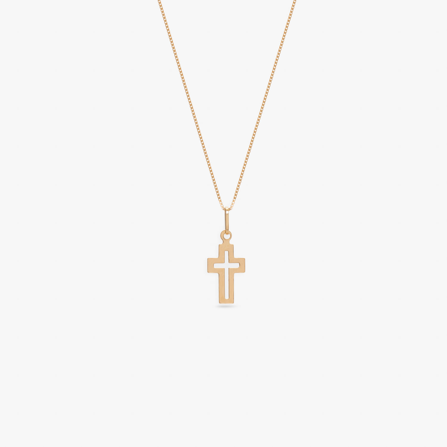 Colar com pingente de cruz dourado em fundo branco.