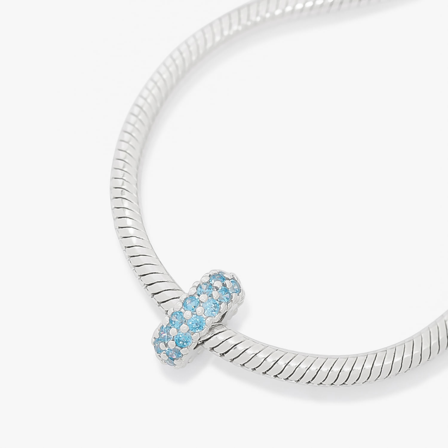 Pulseira de prata com uma peça decorativa com pedras azul claro e brancas.