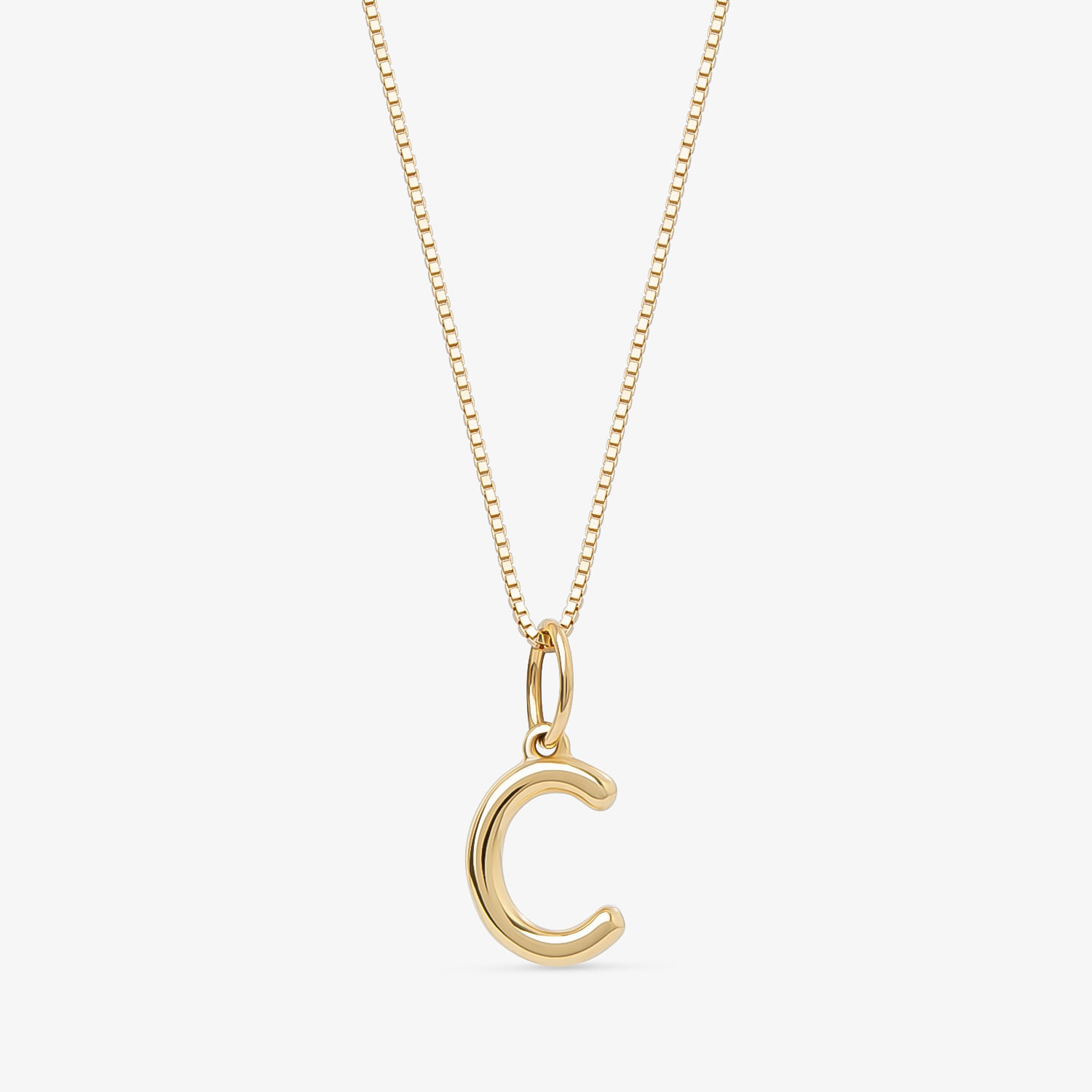 Colar com pingente de letra "C" dourado em corrente fina sobre fundo branco.