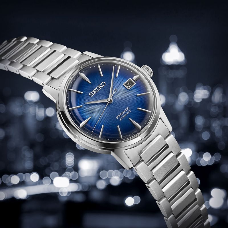 Relógio da Seiko com mostrador azul, pulseira de aço prateada, data e ponteiros dourados.