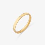 Anel de ouro com uma pedra pequena e transparente, possivelmente um diamante, em uma superfície branca.