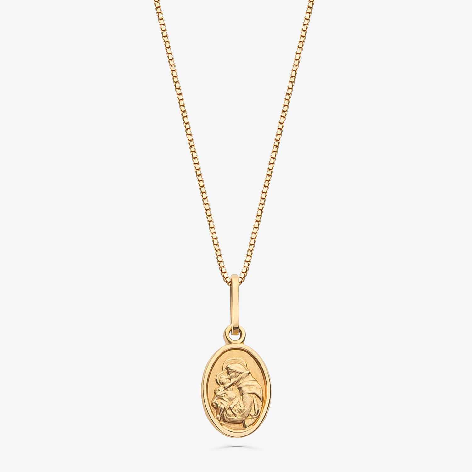 Colar com pingente oval dourado com uma cabeça de leão em relevo.