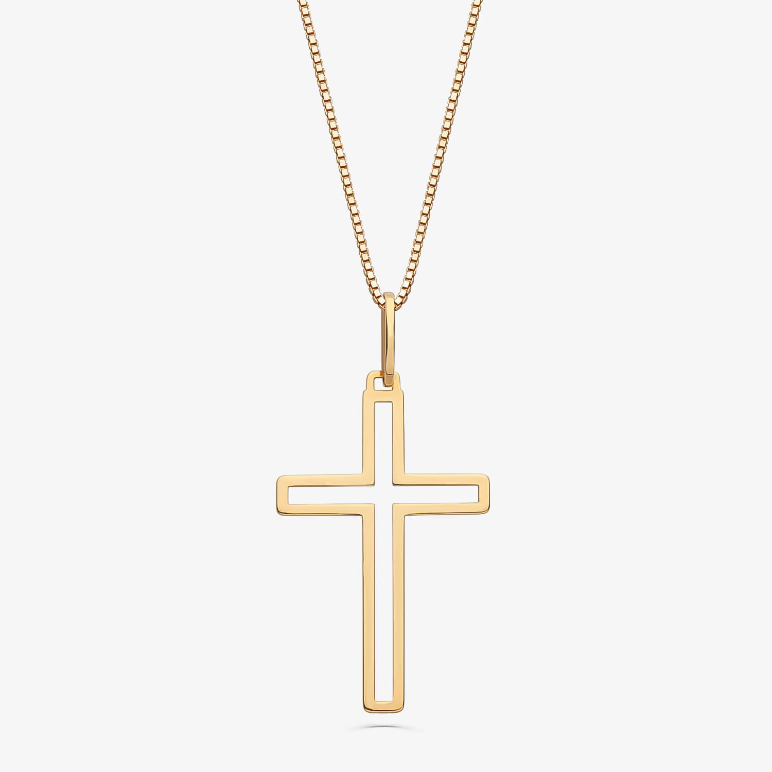 Colar dourado com pingente de cruz em modelo minimalista, pendurado em corrente fina.