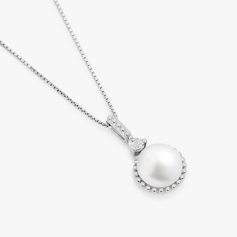 Colar com pingente de pérola branca e detalhes em prata com pequenas pedras brancas na moldura do pingente.