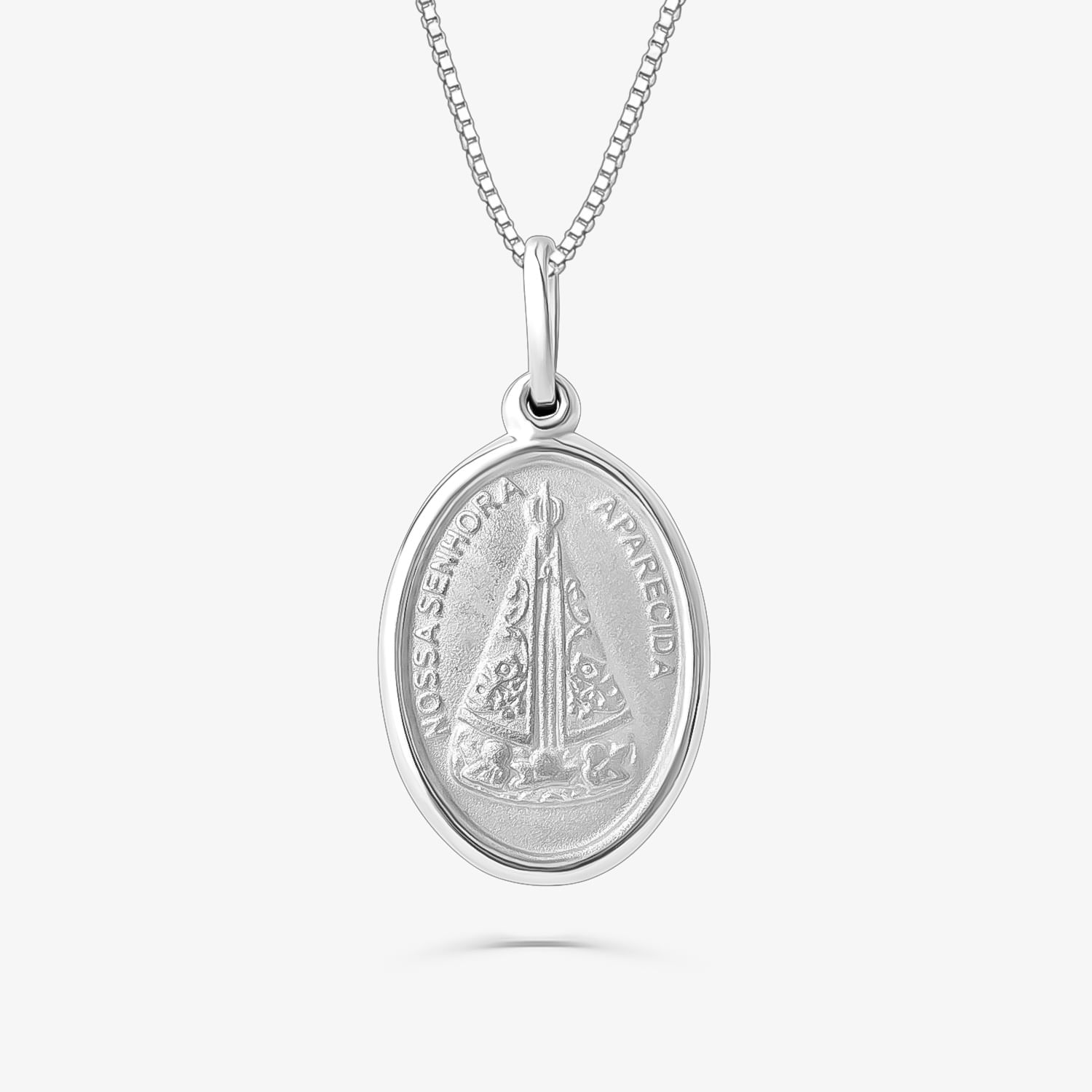 Colar com pingente oval de prata com imagem religiosa e inscrição "Nossa Senhora Aparecida".