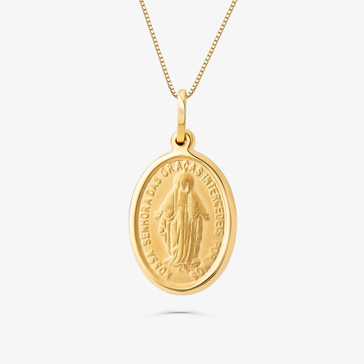 Colar com medalha dourada oval com imagem de santa e texto em volta, em fundo branco.