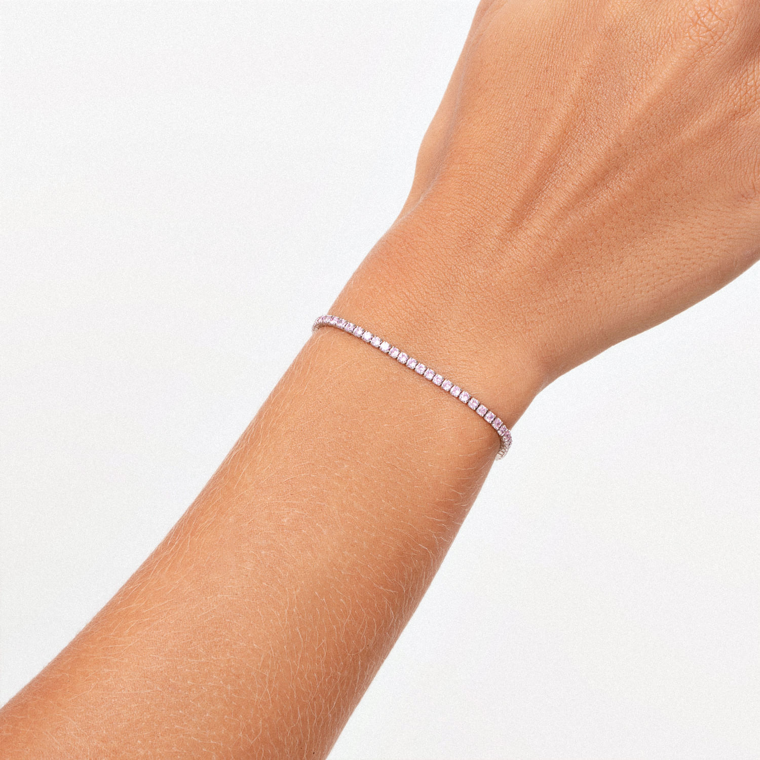 Pulseira delicada com pedras brilhantes em volta do pulso de uma pessoa.