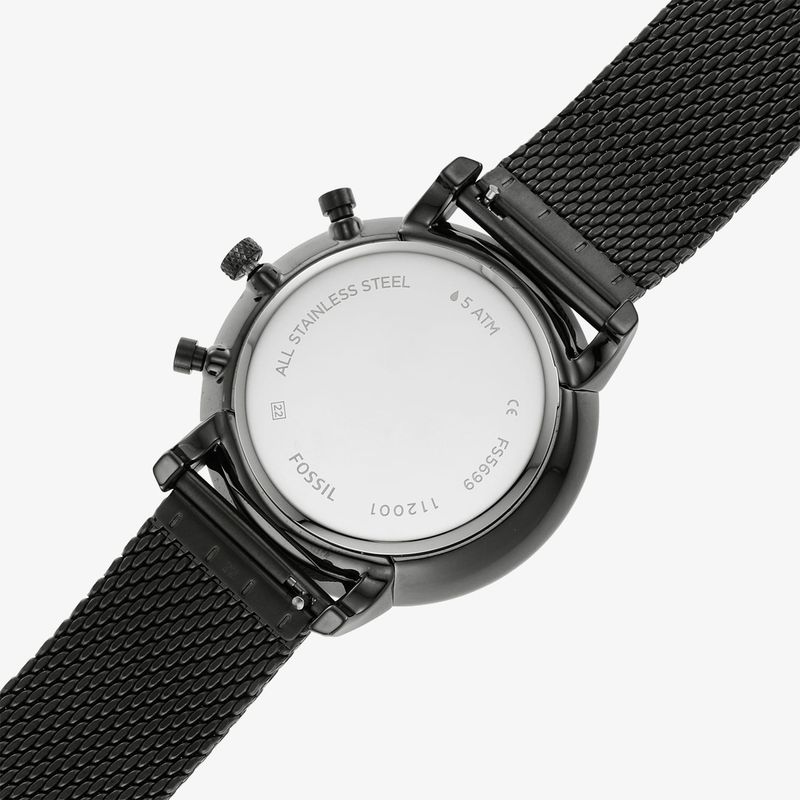 Relógio preto com pulseira de malha metálica, mostrando a parte de trás com detalhes em roxo e informações do fabricante.