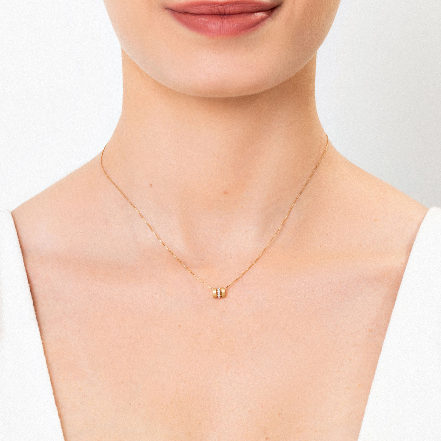 Colar delicado de corrente fina com pingente de pérola e detalhes dourados.
