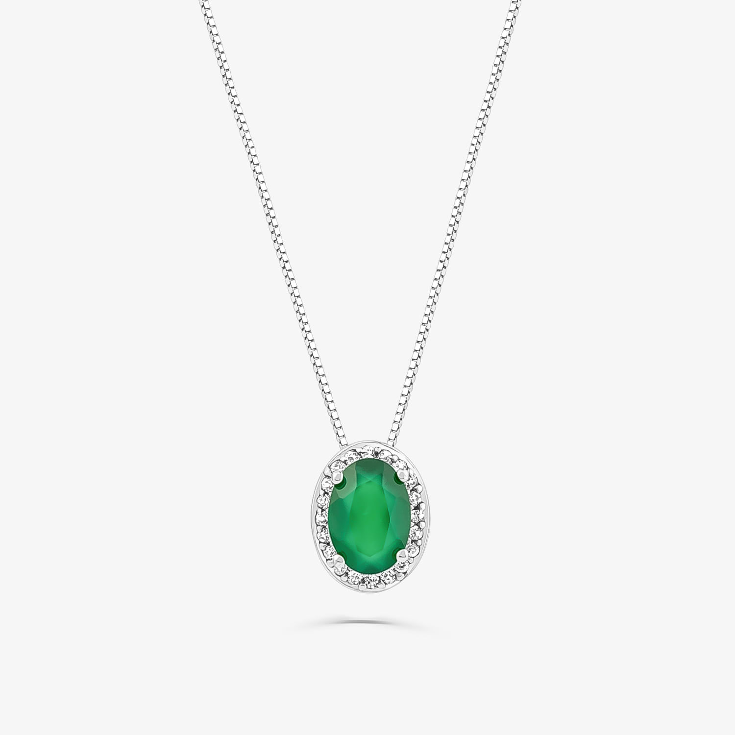 Colar com pingente oval verde, envolto por uma borda de pedras transparentes, em corrente prateada.