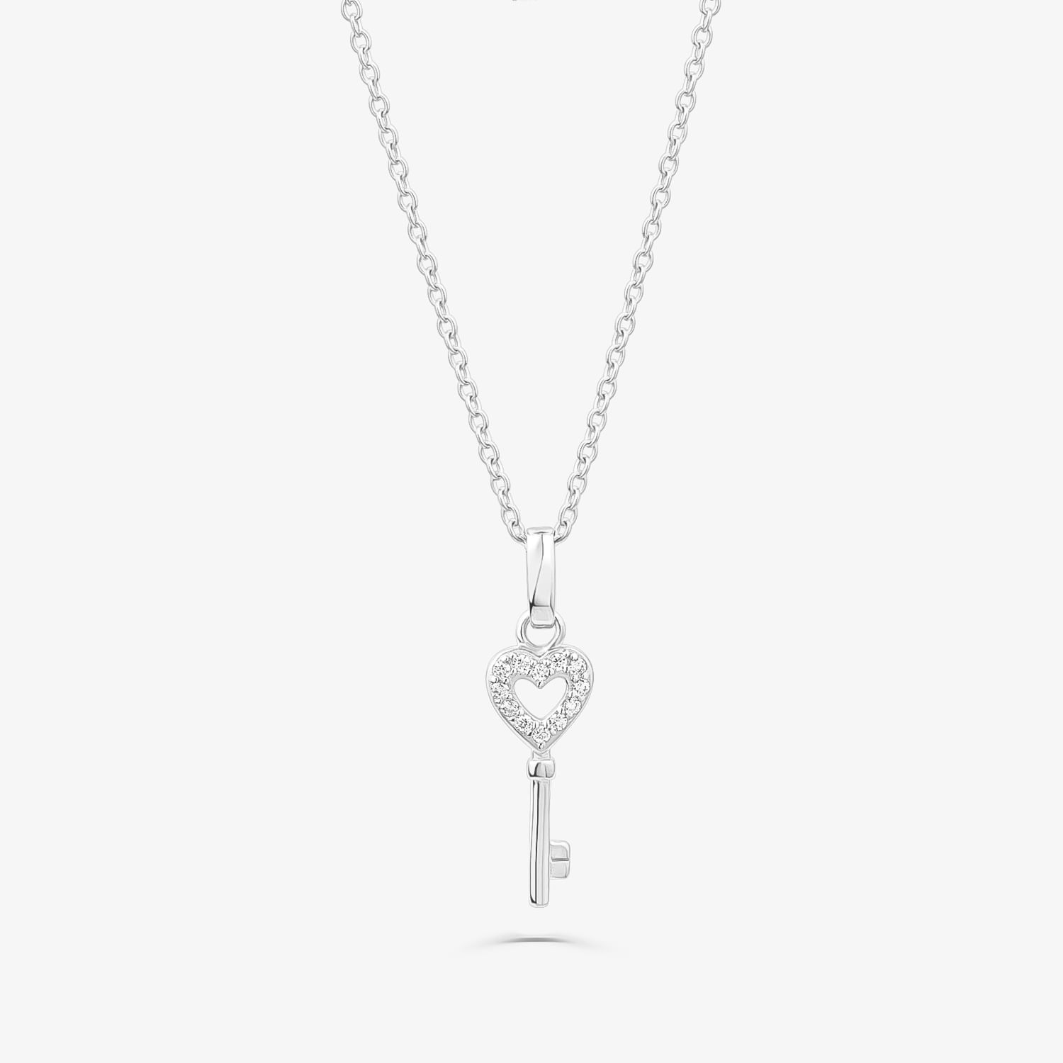 Colar com pingente de coração com detalhes brilhantes e chave pendurada, em acabamento prateado.