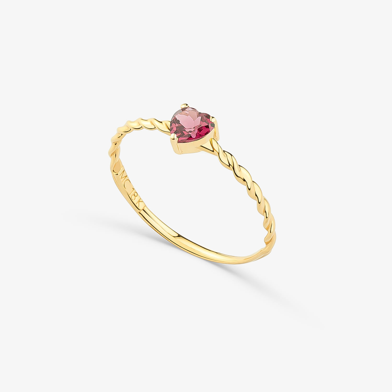 Anel dourado com uma pedra rosa em formato de coração, preso em uma banda com detalhe torcido.