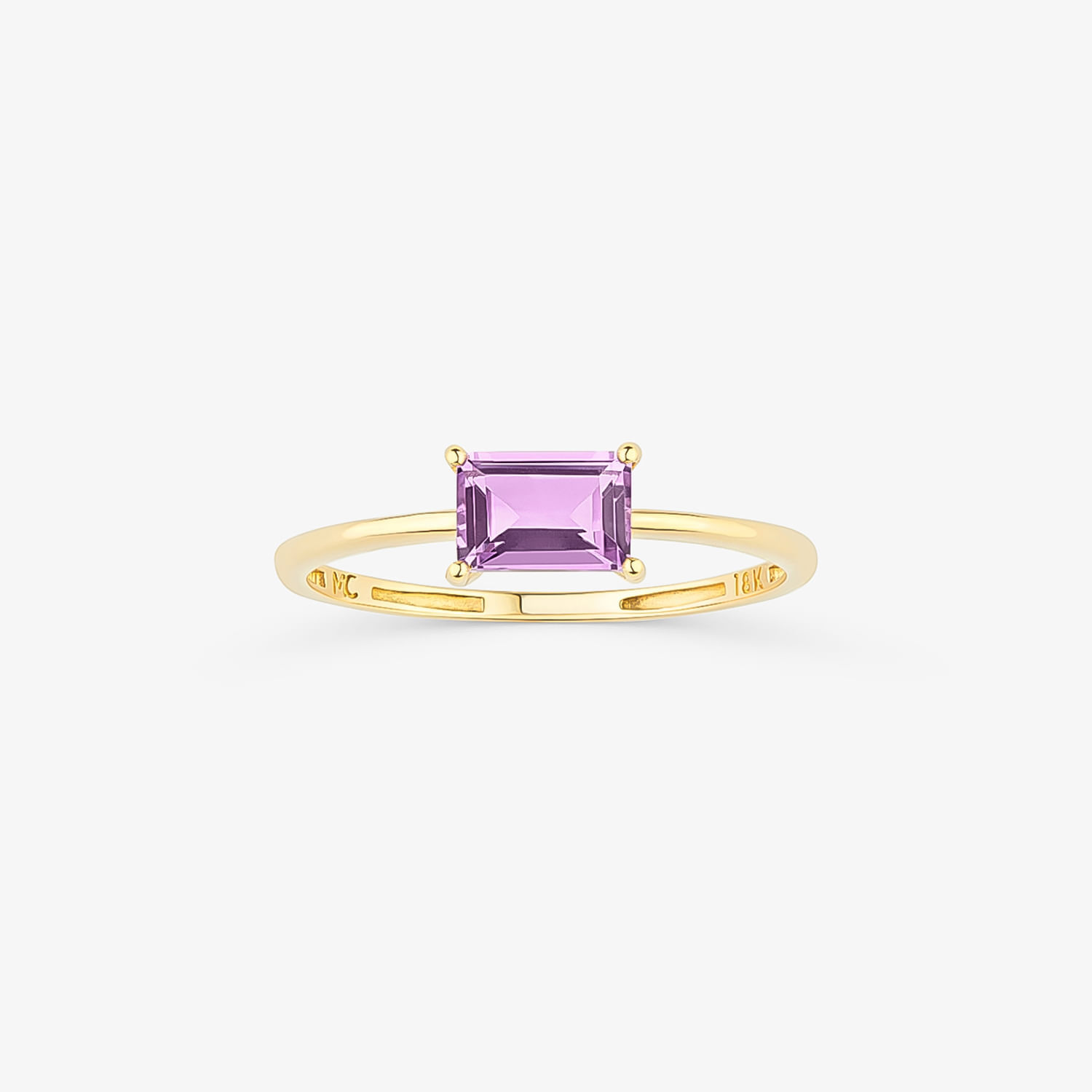 Um elegante anel de ouro com uma pedra preciosa roxa retangular cravejada em quatro garras.